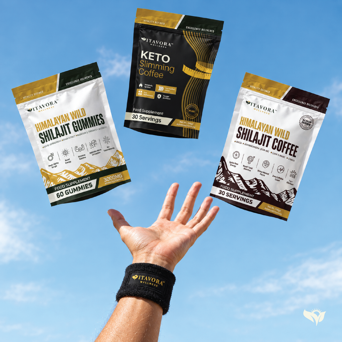 Vitavora Wellness Power Circle Wristband worn while catching the Himalayan Wild Shilajit Gummies, Keto Slimming Coffee, and Shilajit Performance Coffee pouches against a clear blue sky.